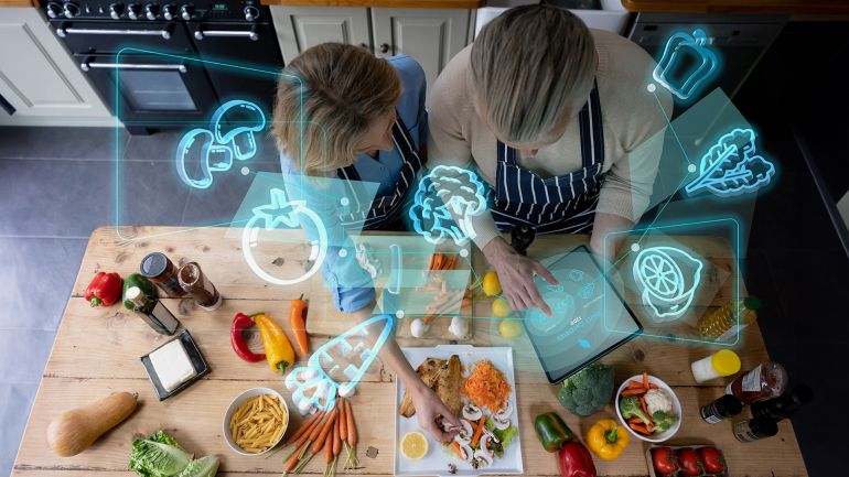 gettyimages-1385970253-1691964067 Senior couple cooking at home and using technology to do a calorie count - using computer concepts