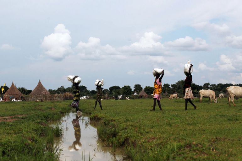 People carry relief food from a distribution by the World Food Programme in South Sudan [File: Andreea Campeanu/Reuters]