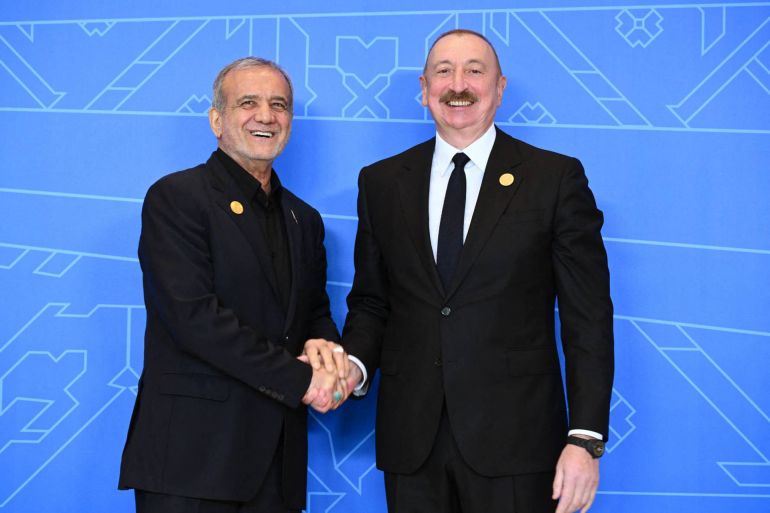 pezeshkian3-1751636200 This handout photograph released by the Azerbaijani presidential press service on July 4, 2025, shows Azerbaijani President Ilham Aliyev and Iranian President Masoud Pezeshkian shaking hands during the 17th Summit of the Economic Cooperation Organization in Khankendi, Azerbaijan. (Photo by Handout / Azerbaijani presidency / AFP) / RESTRICTED TO EDITORIAL USE - MANDATORY CREDIT "AFP PHOTO / AZERBAIJANI PRESIDENCY / HANDOUT / - NO MARKETING NO ADVERTISING CAMPAIGNS - DISTRIBUTED AS A SERVICE TO CLIENTS