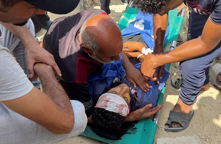 reuters_6898555f-1754813791 SENSITIVE MATERIAL. THIS IMAGE MAY OFFEND OR DISTURB The father of Palestinian boy Muhannad Eid, who died after being struck by a box of airdropped aid, places his hand on his son's chest during the funeral, in Nuseirat, in the central Gaza Strip, August 9, 2025. REUTERS/Stringer