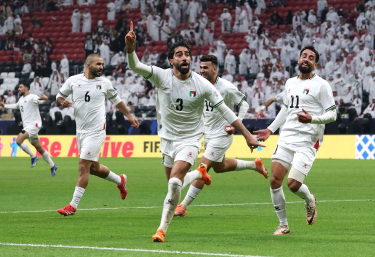 reuters_692dd413-1764611091 Soccer Football - FIFA Arab Cup - Qatar 2025 - Group A - Qatar v Palestine - Al Bayt Stadium, Al Khor, Qatar - December 1, 2025 Palestine's Mohammed Saleh celebrates their first goal with teammates, an own goal scored by Qatar's Sultan Al Brake REUTERS/Mohammed Salem