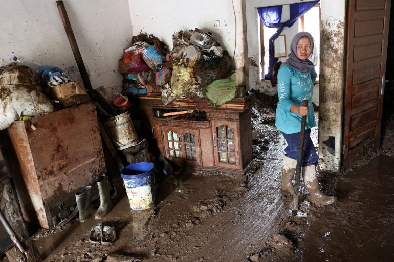 reuters_692ff0d2-1764749522 Ulfa Rahmi, 40, looks on while cleaning her house after deadly landslides following heavy rains in Malalak, Agam regency, West Sumatra province, Indonesia, December 3, 2025. REUTERS/Willy Kurniawan TPX IMAGES OF THE DAY