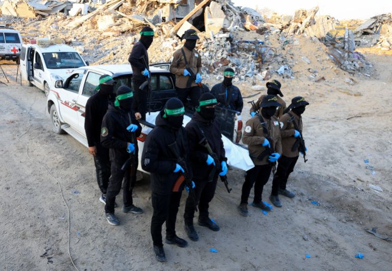 reuters_6930bea1-1764802209 Palestinian Hamas and Islamic Jihad militants wait for Red Cross members to receive a body recovered by them, before it is handed over to Israel to determine whether it belongs to a hostage, in Beit Lahiya, in the northern Gaza Strip, December 3, 2025. REUTERS/Dawoud Abu Alkas