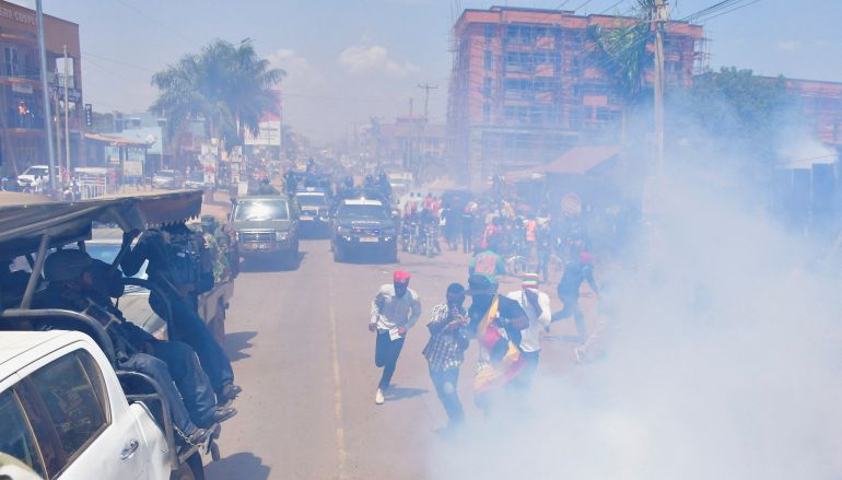 Supporters of Ugandan presidential candidate Robert Kyagulanyi, also known as Bobi Wine, of the National Unity Platform (NUP) party, run as riot police fire tear gas canisters to disperse the crowd during a campaign event ahead of the general elections in Kira Municipality, Wakiso District, on the outskirts of Kampala, Uganda, December 1, 2025. REUTERS/Abubaker Lubowa.