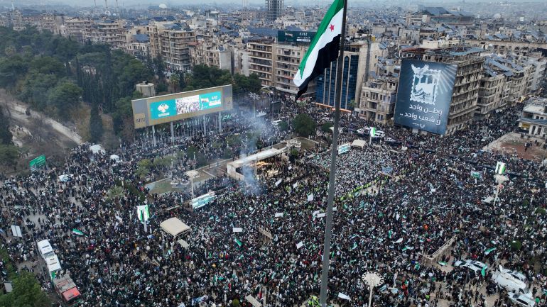 reuters_6937e19f-1765269919 A drone view shows people gathering during a protest to mark the first anniversary of Bashar al-Assad's fall, in Aleppo, Syria December 8, 2025. REUTERS/Mahmoud Hassano