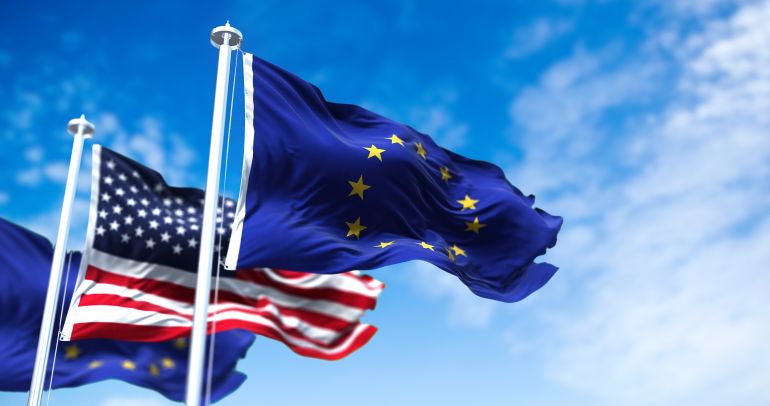 The flags of the European Union and the United States of America waving in the wind. International ...