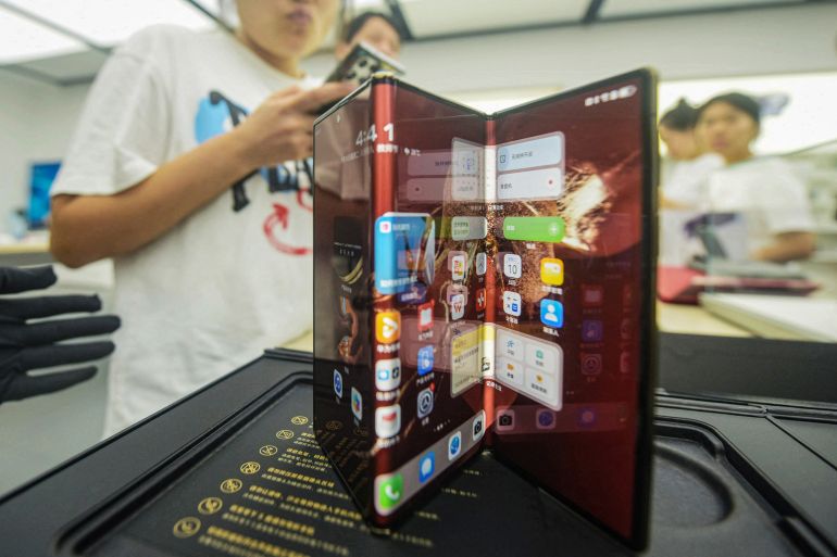 Chinese tech giant Huawei's new trifold phone Huawei Mate XT is displayed during its launch day at a Huawei store in Hangzhou, in eastern China's Zhejiang province on September 10, 2024. - Chinese tech giant Huawei on September 10 unveiled the world's first triple-folding phone at more than three times the price of the newest iPhone, hours after its US competitor lifted the curtain on its own new handset built for AI. (Photo by AFP) / China OUT / CHINA OUT