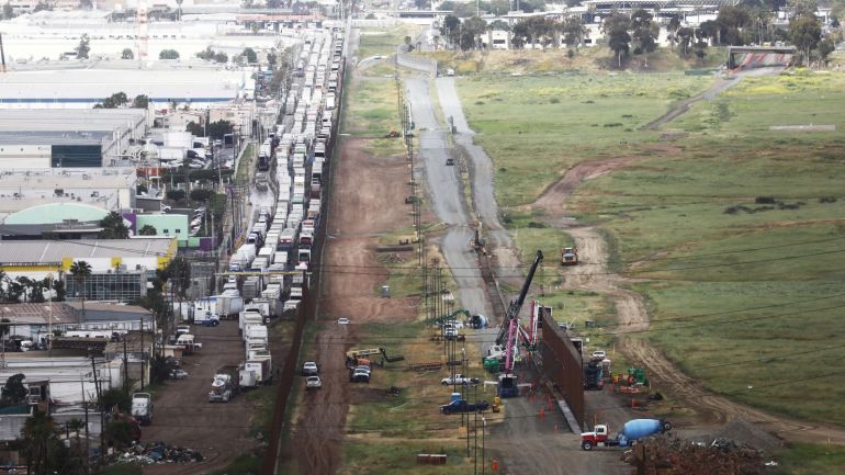 2776e444-0f3b-4ffb-99c3-2742e346cda2 OTAY MESA, CALIFORNIA - APRIL 03: Construction continues on a secondary border barrier on the U.S. side of the U.S.-Mexico border, as trucks are lined up on the Mexican side to enter the U.S. (L), on April 3, 2019 in Otay Mesa, California. The Department of Homeland Security is building 12.5 miles of secondary border barrier in San Diego county as part of U.S. President Donald Trump's Border Security and Immigration Enforcement Improvements executive order. Trump told reporters last week there's a very good likelihood that he will close the U.S. Southern border this week. Mario Tama/Getty Images/AFP== FOR NEWSPAPERS, INTERNET, TELCOS & TELEVISION USE ONLY ==
