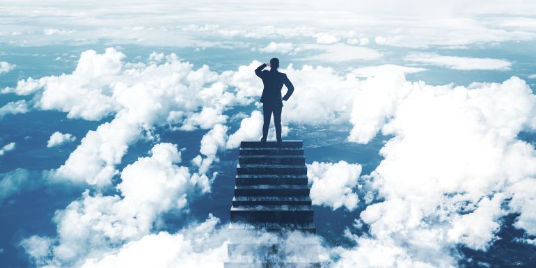 Silhouette of a businessman on top of stairs above the clouds, looking forward. Concept of leadership, vision, and progress in business. The image has a dreamy, surreal quality