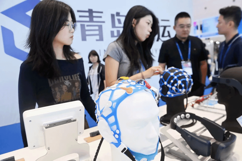 QINGDAO, CHINA - SEPTEMBER 20, 2025 - Visitors learn about brain computer interface facilities at the 2025 GHINA INTERNATIONAL CONLSUMER ELECTRIC EXPO in Qingdao, Shandong Province, China on September 20, 2025. (Photo credit should read CFOTO/Future Publishing via Getty Images)