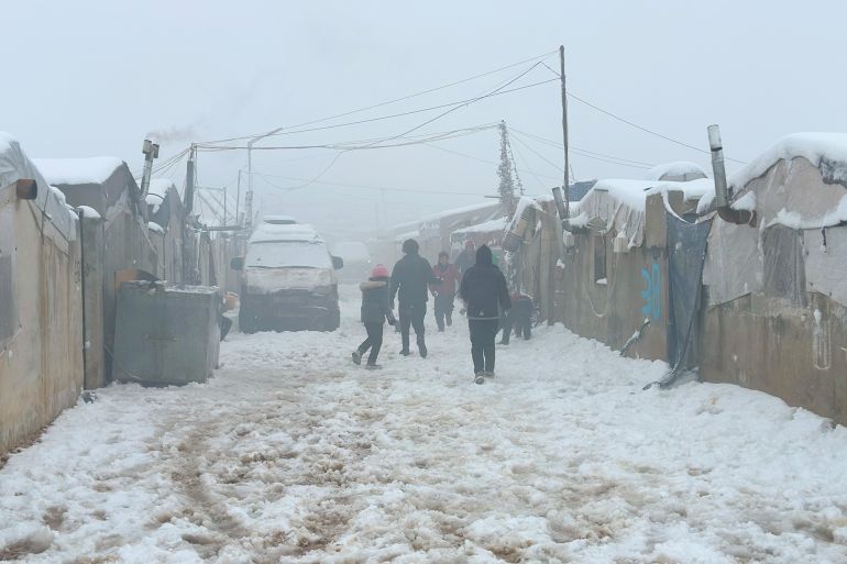 9879651654-1769167567 In Idlib, Syria, on January 01, 2026, heavy snowfall covers refugee camps scattered near the Syrian-Turkish border. Residents struggle to remove snow from their tents amid catastrophic humanitarian conditions. (Photo by Mohammad Daher/NurPhoto via Getty Images)