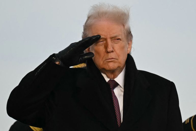 afp_69431a88133a-1766005384 US President Donald Trump salutes as he observes the return of the remains of two Iowa National Guard members and a translator killed in an attack in Syria during a ceremony at Dover Air Force Base in Delaware on December 17, 2025. (Photo by ANDREW CABALLERO-REYNOLDS / AFP)