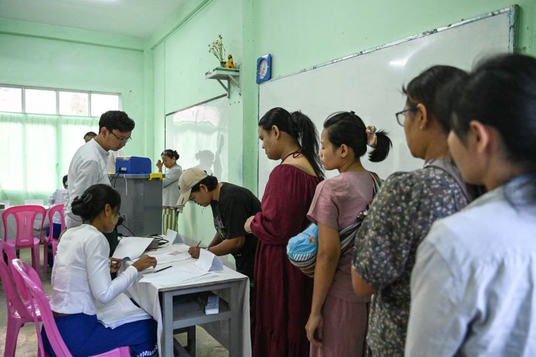 afp_6950841bc34e-1766884379 People line up to vote inside a polling station during the first phase of Myanmar's general election in Yangon on December 28, 2025.