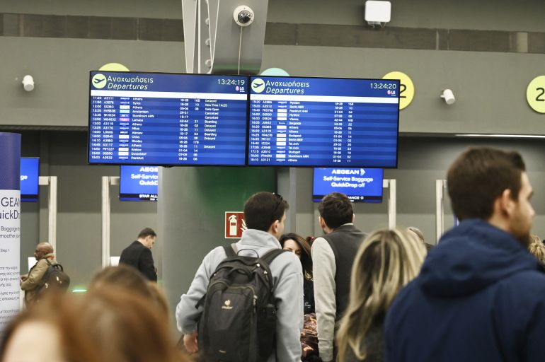 afp_695aa25bee41-1767547483 Passengers wait near a flight information screen at the Thessaloniki Airport "Makedonia" amidst disruption in flights across Greece linked to a technical problem at the Athens Flight Information Region (FIR), in Thessaloniki, on January 4, 2026.