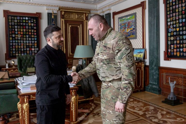 الرئيس الأوكراني فولوديمير زيلينسكي(يسار) يصافح رئيس جهاز الأمن الوطني فاسيل ماليوك بعد إعلان عزله من منصبه