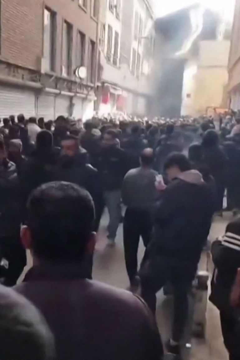 afp_695d5d58963c-1767726424 This grab taken on January 6, 2026, from UGC images posted on social media the same day shows people gathering in the Tehran bazaar during clashes between security forces and protesters.