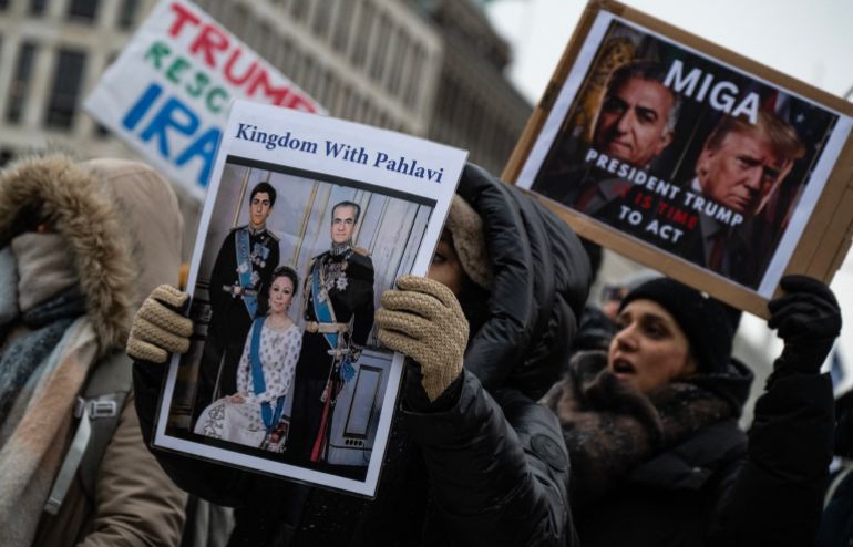A demonstrator displays a placard featuring an official portrait of former Iranian ruler Mohammed Reza Pahlavi, his wife Farah and Son Reza Pahlavi (C) during an anti-Iranian-government protest in Berlin, Germany, on January 12, 2026.
