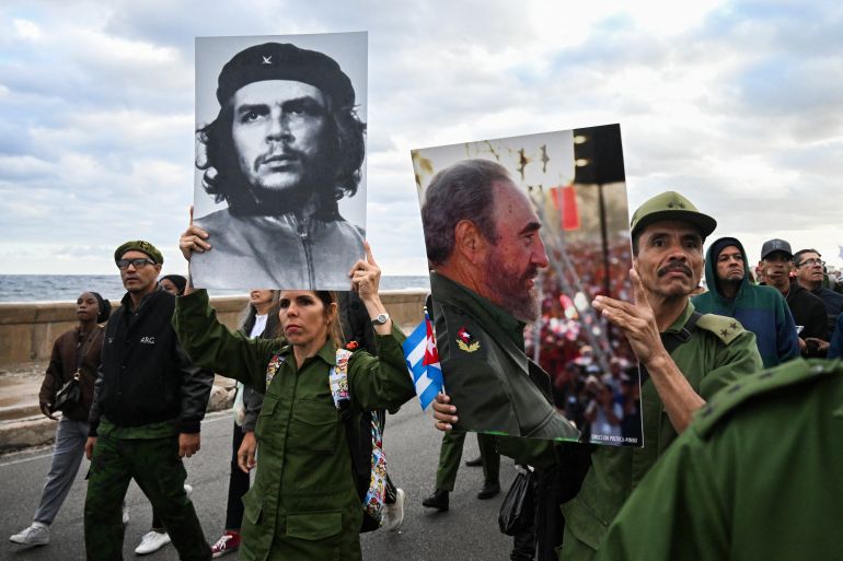 TOPSHOT - Cubans hold images of revolutionary hero Ernesto ‘Che’ Guevara and the late Cuban leader Fidel Castro during an "Anti-Imperialist" protest in front of the US Embassy against the US incursion in Venezuela, where 32 Cuban soldiers lost their lives, in Havana on January 16, 2026.