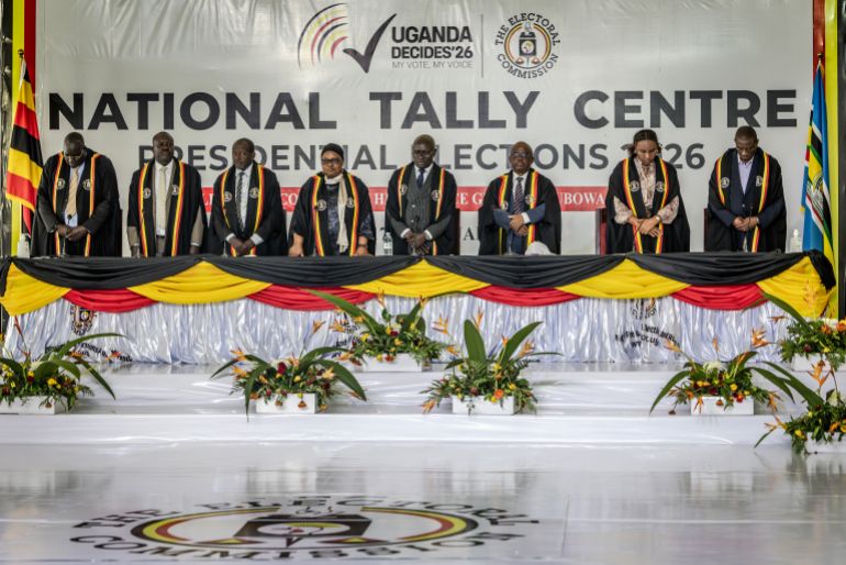 afp_696aa4d7668c-1768596695 Senior commissioners from Uganda’s Electoral Commission stand during the announcement of partial results from Uganda’s 2026 presidential election as vote counting continues at the National Tally Centre in Kampala on January 16, 2026. (Photo by Luis TATO / AFP)