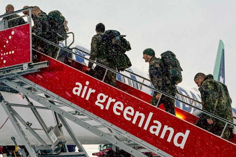 afp_696ce8b07283-1768745136 Military personnel from the German armed Forces Bundeswehr board the Icelandair flight leaving Nuuk airport for Reykjavik on January 18, 2026 in Nuuk, Greenland.