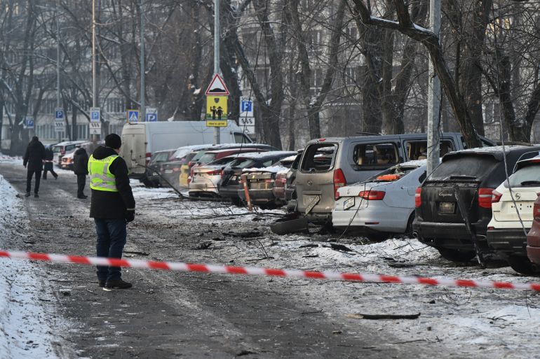 afp_696f56c27f08-1768904386 Residents survey damaged cars at the site where Russian drone debris fell during a large-scale Russian aerial attack in Kyiv on January 20, 2026, amid the Russian invasion of Ukraine. (Photo by Genya SAVILOV / AFP)