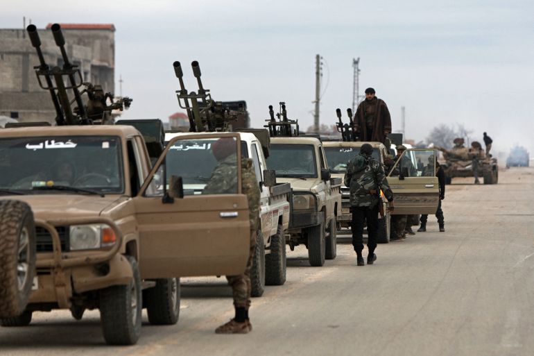 afp_696fd9c47861-1768937924 Syrian army soldiers along with their armoured vehicles gather as they prepare to enter the town of Deir Hafer on January 17, 2026.