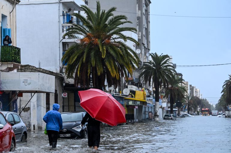 TOPSHOT - Residents make their way through flood waters, in La Goulette near the capital Tunis, on Januray 20, 2026.