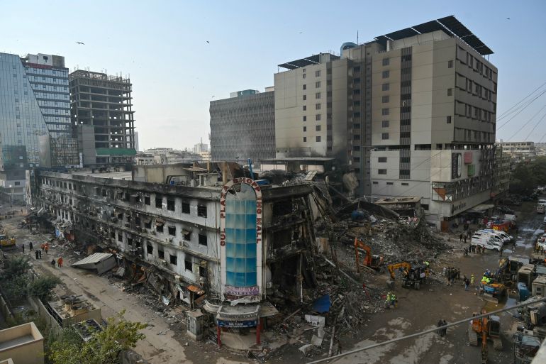 afp_6971d15bb99f-1769066843 Workers clear debris of a shopping mall in Karachi on January 22, 2026, after a massive fire broke out on January 17.