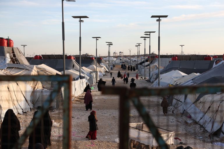 afp_6973431a080a-1769161498 TOPSHOT - Children and women, relatives of suspected Islamic State jihadists, walk inside Al-Hol camp in the desert region of Syria's northeastern Hasakeh province on January 21, 2026.