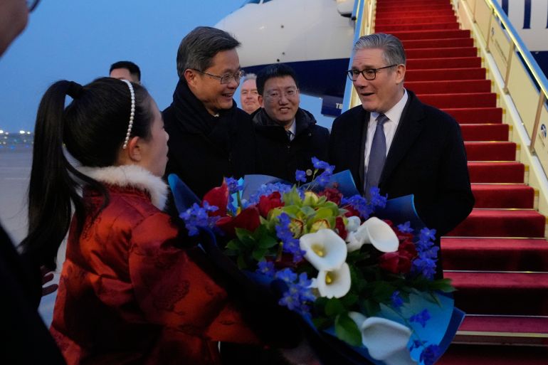 Britain's Prime Minister Keir Starmer receives a bouquet of flowers upon his arrival at an airport in Beijing, China, Wednesday, Jan. 28, 2026. (AP Photo/Kin Cheung, Pool)