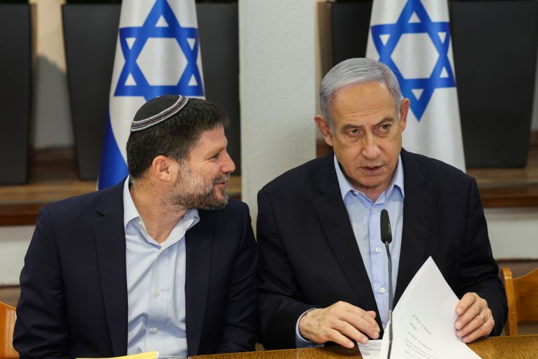 Israeli Prime Minister Benjamin Netanyahu, right, speaks with Minister of Finance Bezalel Smotrich during the weekly cabinet meeting at the Defence Ministry in Tel Aviv, Israel, Sunday Jan. 7, 2024. (Ronen Zvulun/Pool via AP)