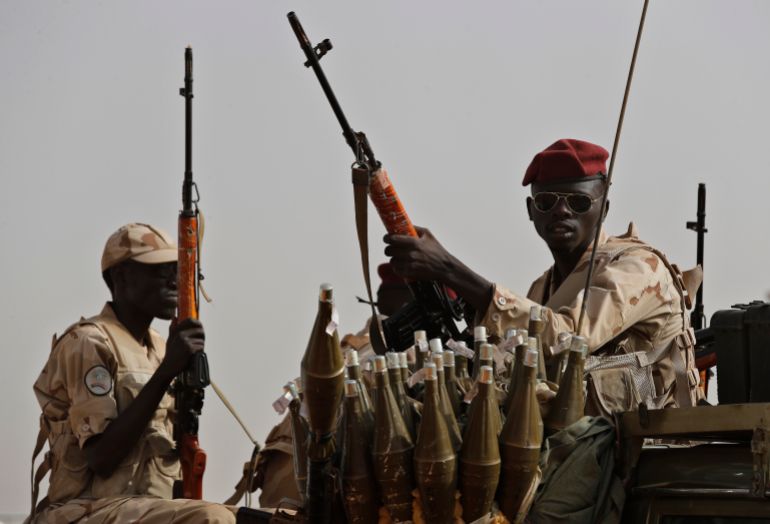 ap_69365920dd344-1765169440-1 FILE - Sudanese soldiers from the Rapid Support Forces unit, led by Gen. Mohammed Hamdan Dagalo, the deputy head of the military council, secure the area where Dagalo attends a military-backed tribe's rally, in the East Nile province, Sudan, June 22, 2019. (AP Photo/Hussein Malla, File)