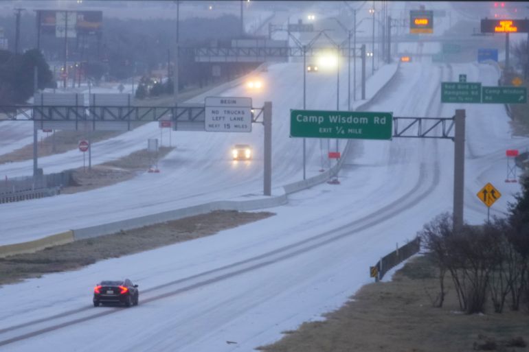 Vehicles move on snow-covered Highway 67 during a winter storm Saturday, Jan. 24, 2026, in Dallas. (AP Photo/Julio Cortez)