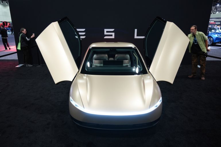 ap_697bb03350066-1769713715 Attendees take pictures of the Tesla Cybercab at the AutoMobility LA auto show in Los Angeles, Thursday, Nov. 21, 2024. (AP Photo/Jae C. Hong)