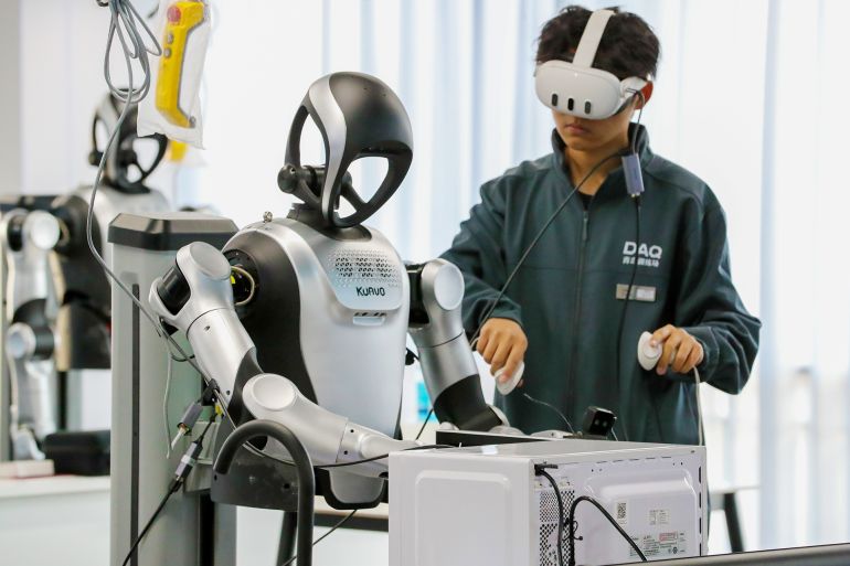 A humanoid robot learns how to clean a microwave oven at the Humanoid Robot Data Collection Training Ground in Qingdao, Shandong, China, on January 12, 2026. (Photo by Costfoto/NurPhoto via Getty Images)