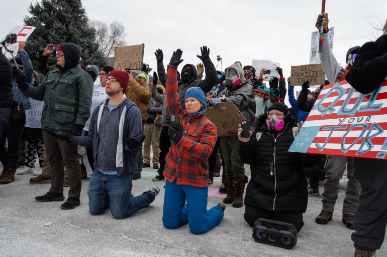 epa12652555 People kneel in front of law enforcement officers during an anti-ICE protest outside the Whipple Federal Building, a base for federal immigration enforcement operations, in Fort Snelling, Minnesota, USA, 15 January 2026. As part of a federal immigration crackdown involving over 2,000 agents from Border Patrol, Immigration and Customs Enforcement (ICE), and Homeland Security Investigations (HSI), an ICE officer fatally shot US citizen Renee Nicole Good in her vehicle during an operation in South Minneapolis on 07 January 2026. EPA/OLGA FEDOROVA