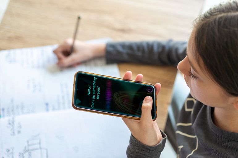 Young girl uses AI virtual assistant to do schoolwork.Concept of Artificial Intelligence and Futuristic technology