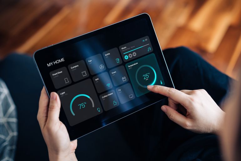 Cropped shot of young woman setting up intelligent home system, controlling smart home appliances with control panel of a smart home. Home automated system controlled from a dashboard. Smart living. Lifestyle and technology. Smart home technology concept