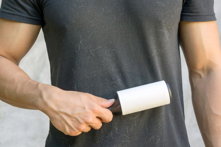 Man holding a hair removal roller.