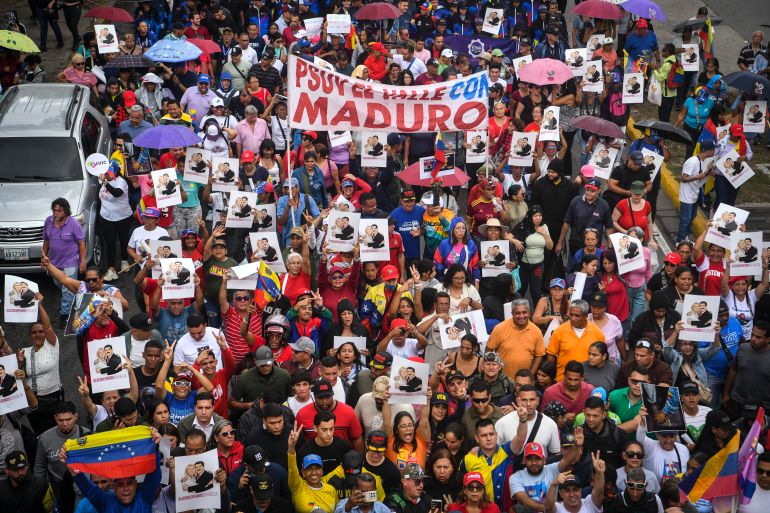 getty_6962dd466b-1768086854 CARACAS, VENEZUELA - JANUARY 10: Demonstrators lift signs depicting Nicolás Maduro and Cilia Flores during a protest in support of Nicolas Maduro on January 10, 2026 in Caracas, Venezuela. Maduro and his wife were captured by US forces on the early morning of January 3 in Caracas and later transported to New York. Maduro and Cilia Flores face the US justice, accused of being part of a conspiracy to send drugs to the US. (Photo by Carlos Becerra/Getty Images)