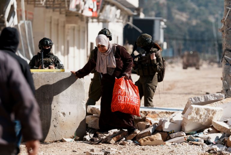 gettyimages-2251749046-1768229780 TULKAREM, WEST BANK - DECEMBER 17: Israeli troops force Palestinians who attempted to enter the camp to retrieve their belongings to leave as Israeli army continues its attacks on the Nur Shams Camp in the city of Tulkarem in the West Bank on December 17, 2025. Israeli forces demolished numerous homes in the camp. (Photo by Issam Rimawi/Anadolu via Getty Images)