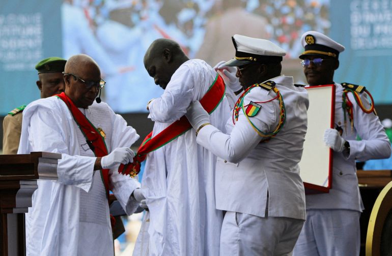 pic-87742-1768679119 حفل تنصيب الجنرال مامادي دومبويا رئيسا لغينيا Guinea's President‑elect Mamady Doumbouya is assisted ahead of taking the oath of office during a swearing‑in ceremony in Conakry, Guinea, January 17, 2026. REUTERS/Stringer