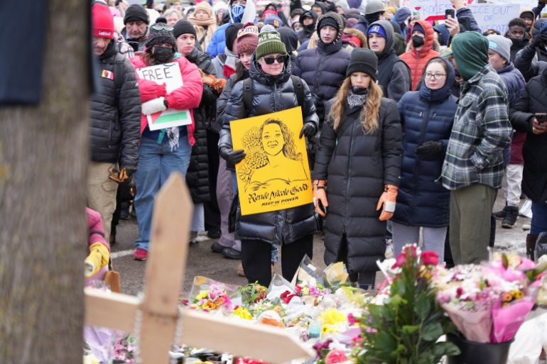 reuters_6962f098-1768091800 People react as they stand before a makeshift memorial during an "ICE Out of Minnesota" rally and march organized by MIRAC (Minnesota Immigrant Rights Action Committee), days after the fatal shooting of Renee Nicole Good by an ICE agent, in Minneapolis, Minnesota, U.S., January 10, 2026. REUTERS/Tim Evans