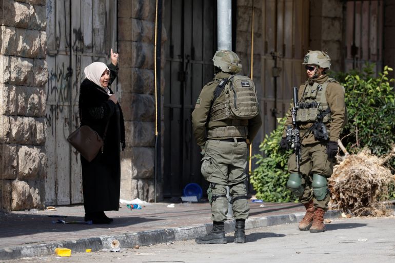 reuters_69711fd2-1769021394-1 A Palestinian woman speaks to Israeli soldiers during an Israeli military multi-day raid in Hebron, in the Israeli-occupied West Bank January 21, 2026. REUTERS/Mussa Qawasma