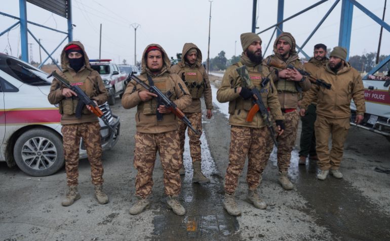 reuters_69730553-1769145683 Members of the Syrian military police gather outside al-Aqtan prison, where some Islamic State detainees are held, in Raqqa, Syria January 22, 2026. REUTERS/Karam al-Masri