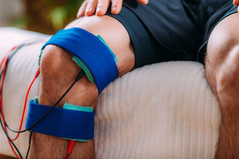 Knee Interferential Therapy with Electrode Brace Pads. Electrotherapy.