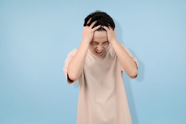 frustrated young man yelling in anger against a blue background ; Shutterstock ID 2675608125; purchase_order: aj; job: ; client: ; other:
