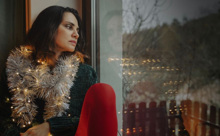 Young woman celebrating christmas with sad expression at home