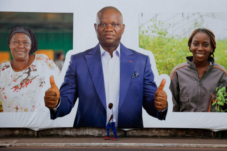 54d8a8d984d98a-1744121899 A man walks past a sign showing Brice Clotaire Oligui Nguema, presidential candidate and Gabonese junta leader, ahead of the 2025 Gabonese presidential election in Libreville, Gabon April 7, 2025. REUTERS/Luc Gnago TPX IMAGES OF THE DAY