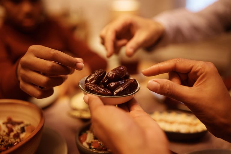 Close up of Muslim family eating dates during Iftar meal at dining table. ramadan رمضان